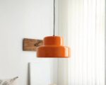 Suspension vintage orange design en acier robuste allumée dans un salon