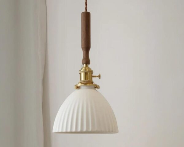 Suspension céramique ambiance chaleureuse, allumée, de couleur blanche et suspendue. Fond beige clair.