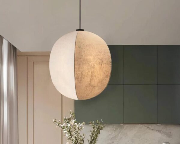 Suspension lin élégance japonaise, de couleur beige, suspendue au-dessus d'une plante et situe dans une pièce de vie.