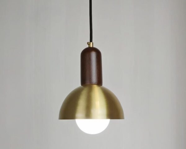 Petite suspension en cuivre de style champignon sur fond gris.