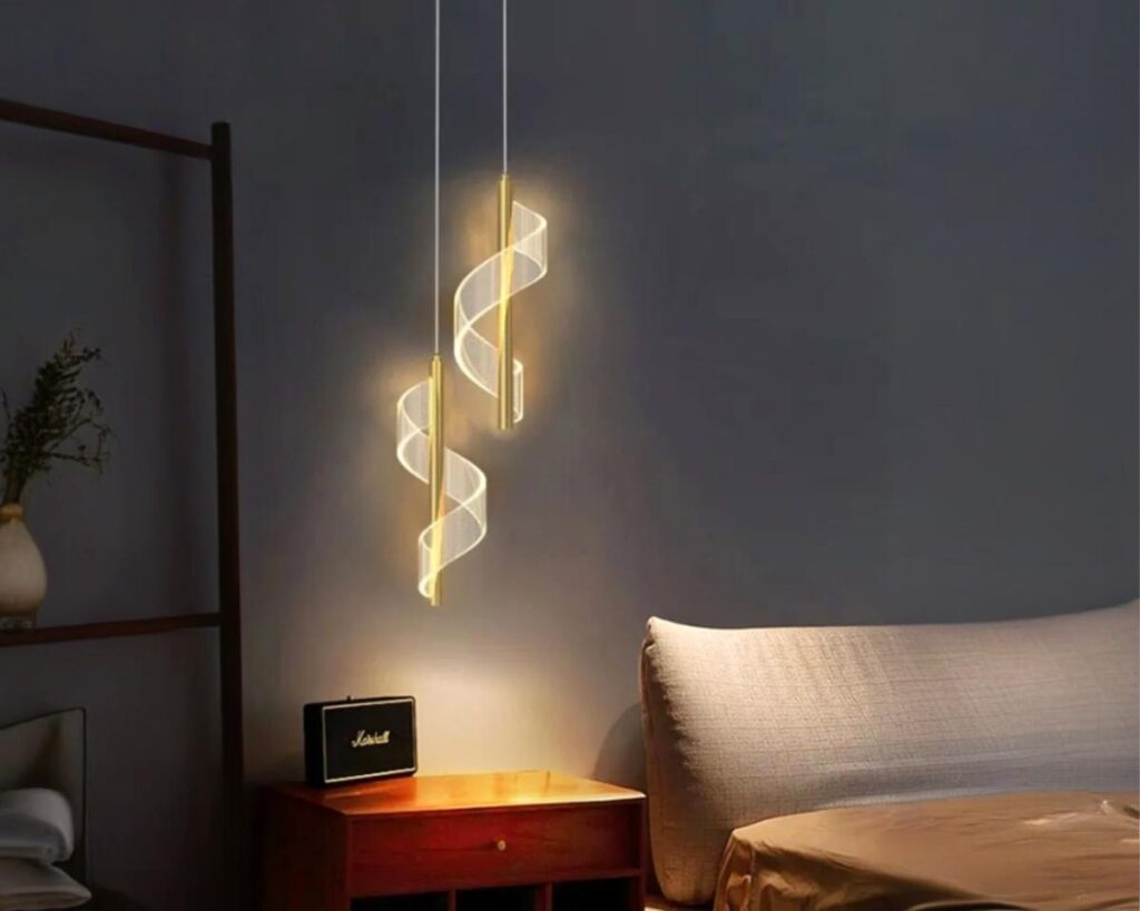 Suspension 2 lampes dorée au design spirale allumée dans une chambre