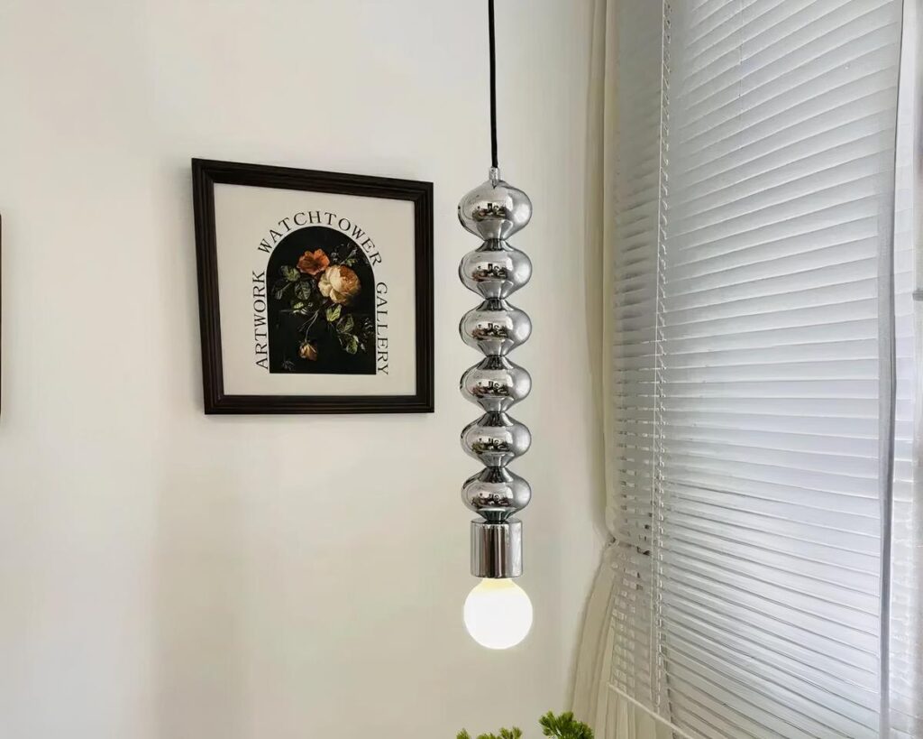 Suspension ampoule argentée et élégante au design innovant allumée dans un intérieur