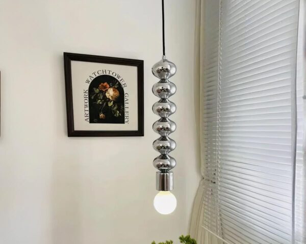 Suspension ampoule argentée et élégante au design innovant allumée dans un intérieur