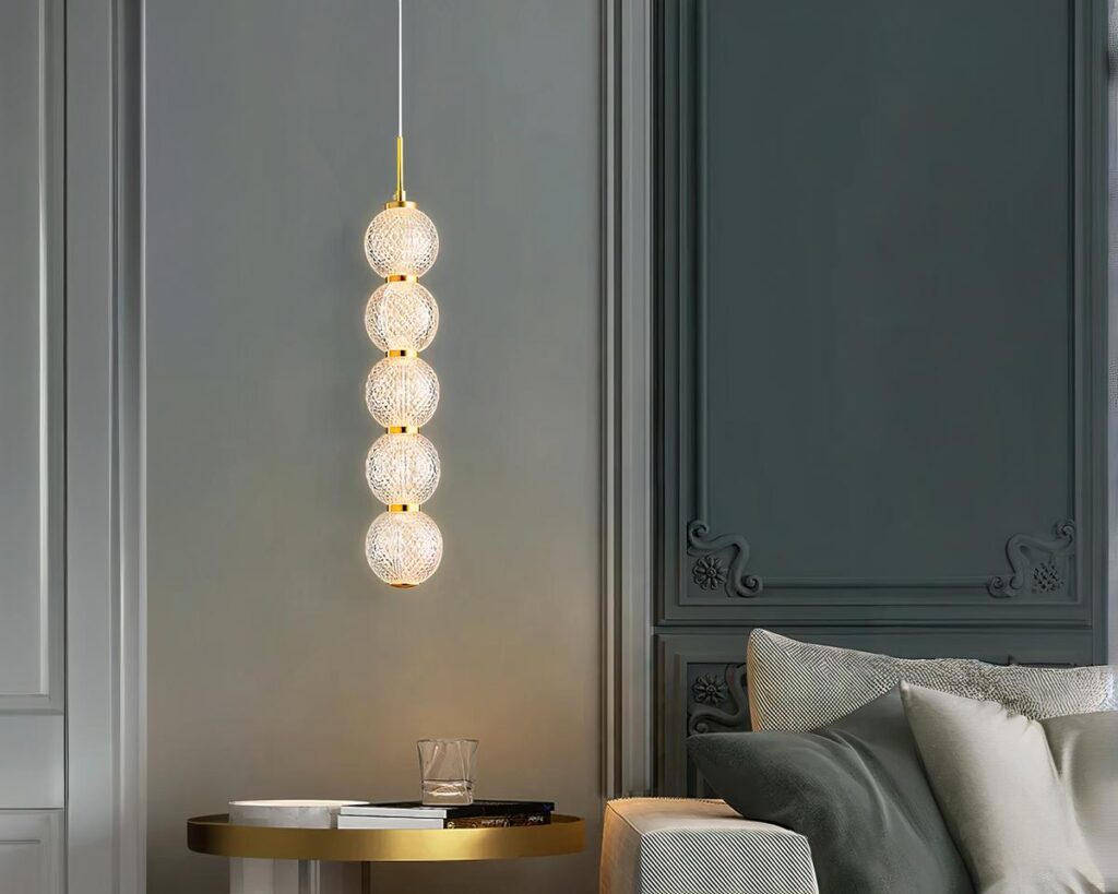 Suspension ampoule dorée et chic au style luxueux allumée dans un salon