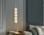 Suspension ampoule dorée et chic au style luxueux allumée dans un salon