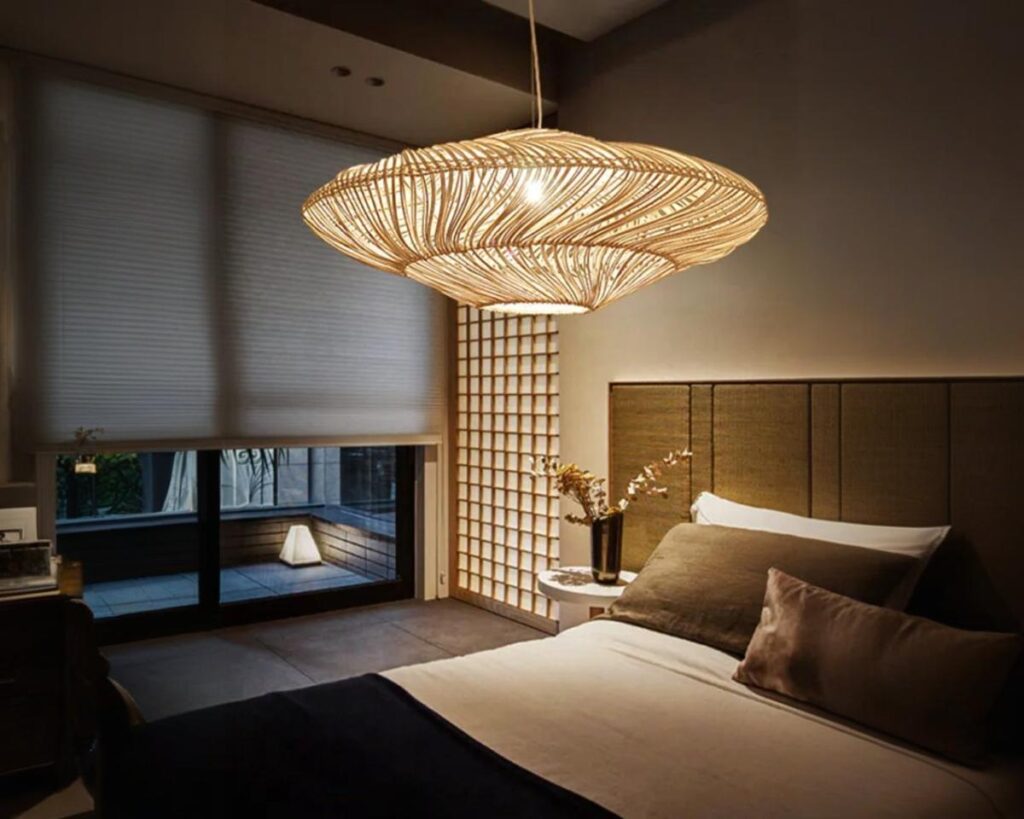 Suspension bali en rotin ambiance japonaise, suspendue et allumée. Située dans une chambre d'adulte à l'allure cosy.