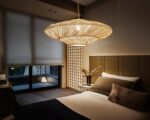 Suspension bali en rotin ambiance japonaise, suspendue et allumée. Située dans une chambre d'adulte à l'allure cosy.