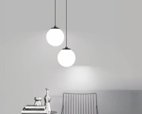 Suspension boule élégante et raffinée au style nordique allumée dans un salon.