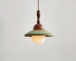 Suspension céramique design rétro, de couleur verte et bois. Fond beige clair.