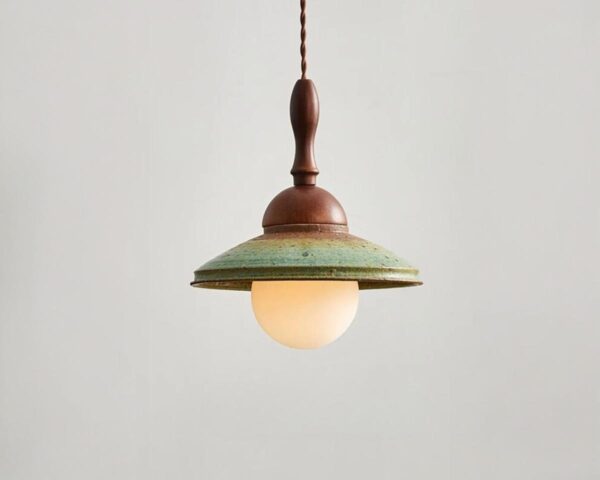 Suspension céramique design rétro, de couleur verte et bois. Fond beige clair.