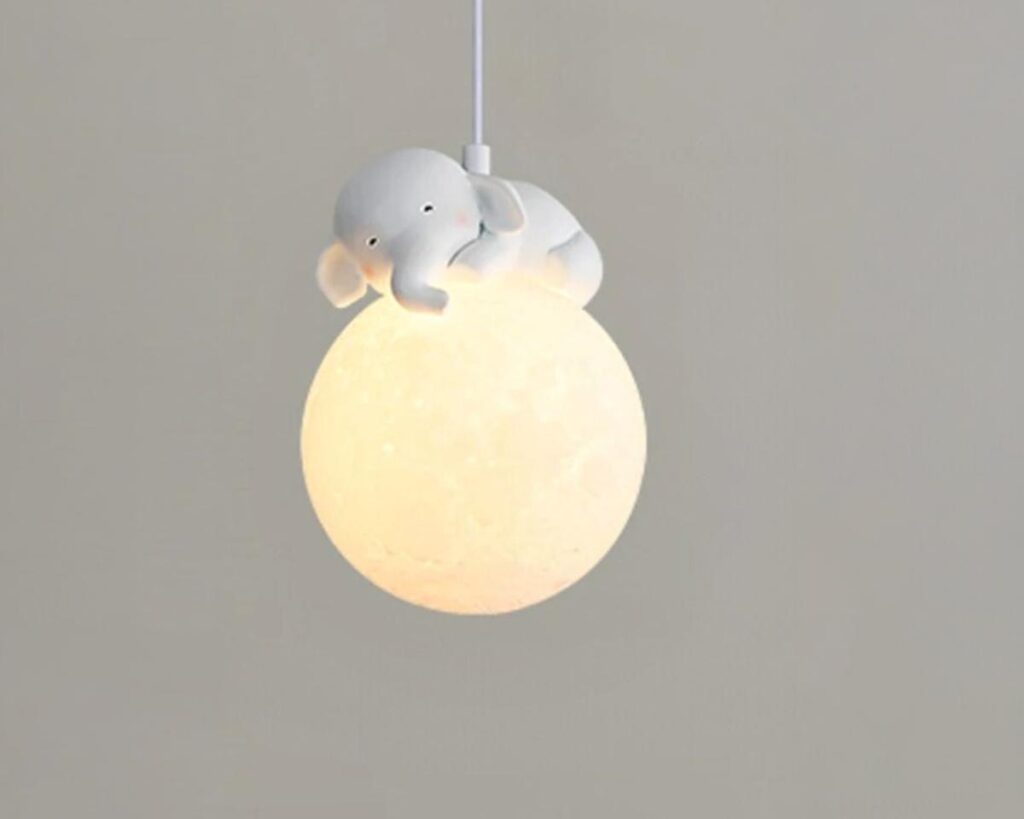Suspension chambre enfant compagnon de nuit, en forme d’éléphant sur une lune jaune et éclairée.