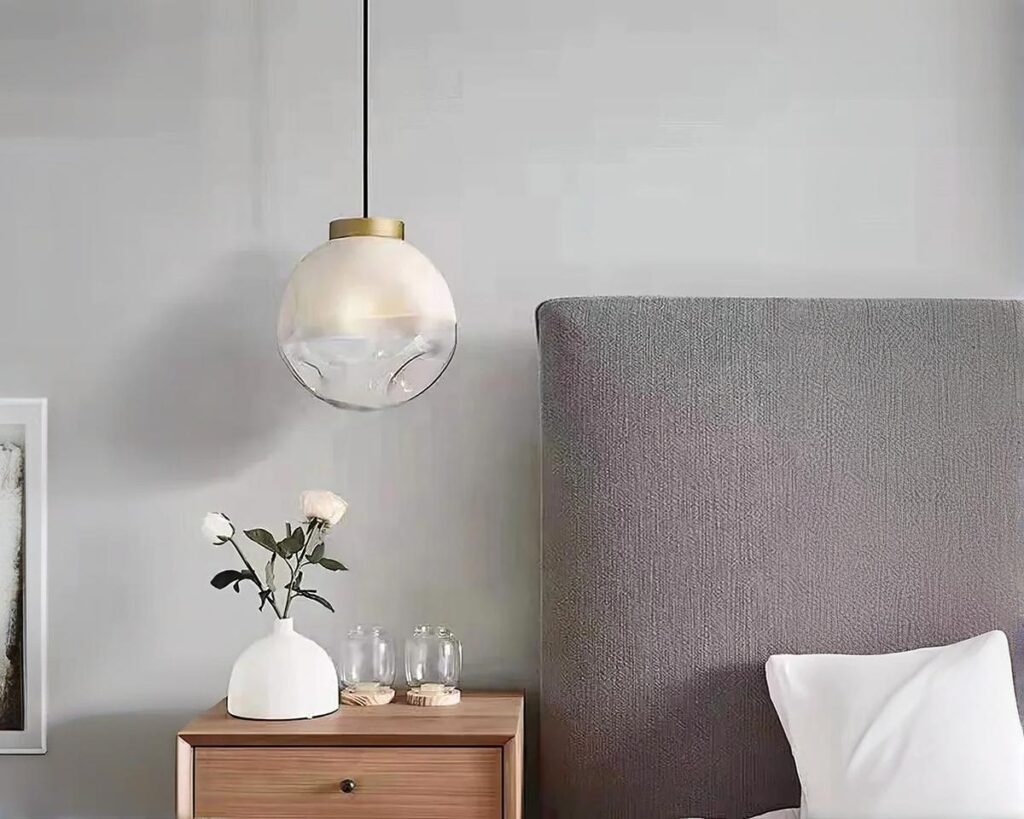 Suspension filaire chic et moderne en boule de verre allumée dans une chambre