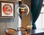 Suspension globe élégante et moderne au design innovant allumée dans une salle à manger au-dessus d'une table