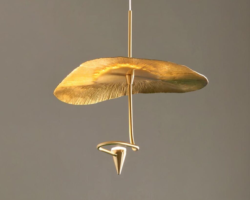 Suspension laiton dorée et originale sur fond gris.