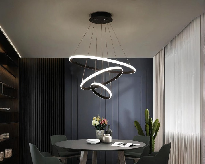 Suspension LED au design originale et innovant noire allumée dans une salle à manger