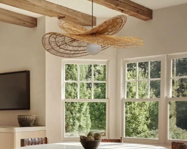 Suspension libellule sculpture raffinée, suspendue au-dessus d'une table blanche dans une ambiance cosy.