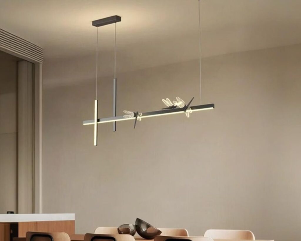 Suspension libellule silhouette élégante, de couleur noire, suspendue et allumée au-dessus d'une table de salle à manger.