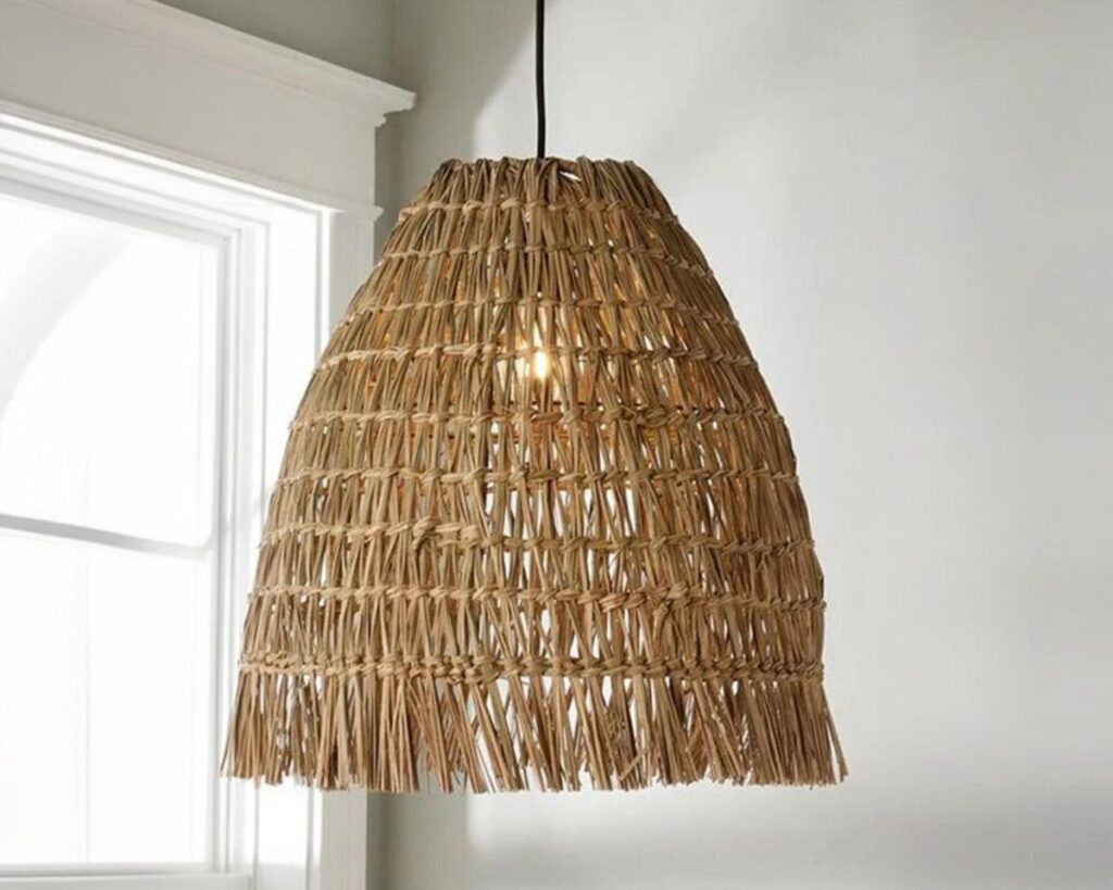 Suspension marocaine en rotin ambiance chaleureuse, avec la lumière allumé, de couleur beige naturel et suspendu. Le fond est beige clair.