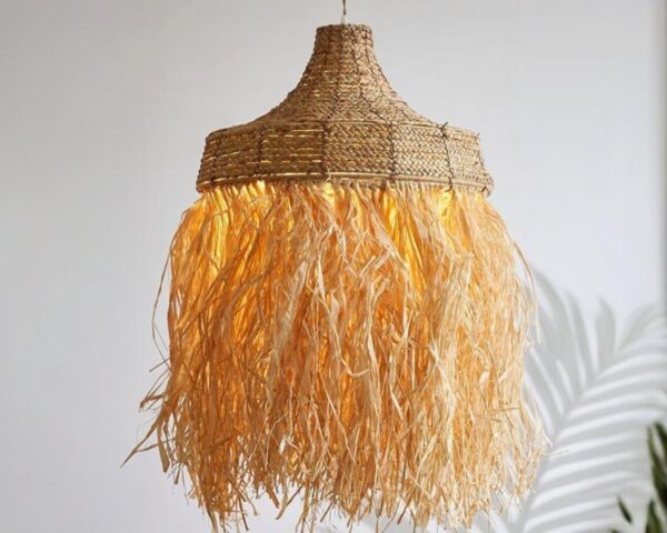 Suspension marocaine en rotin bohème chic, allumé et suspendu, sur fond beige.