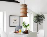 Suspension osier ambiance chaleureuse, de couleur beige, suspendue au-dessus d'une table et dans un décor blanc.