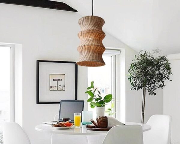 Suspension osier ambiance chaleureuse, de couleur beige, suspendue au-dessus d'une table et dans un décor blanc.