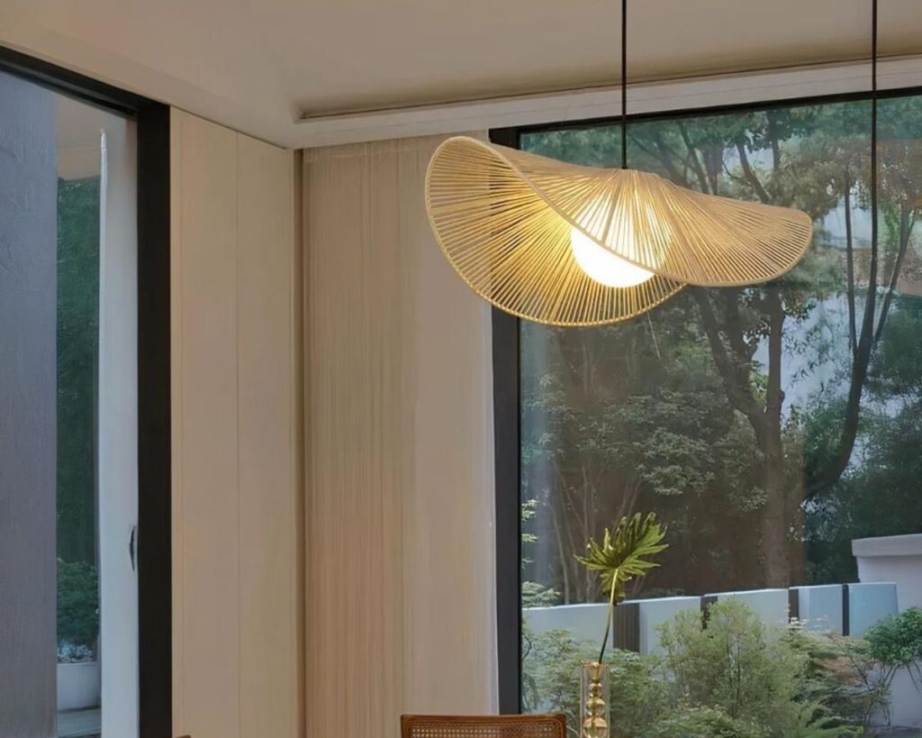 Suspension osier élégance aérienne, de couleur blanche, allumée et suspendue au-dessus d'une table de salle à manger en bois.