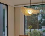 Suspension osier élégance aérienne, de couleur blanche, allumée et suspendue au-dessus d'une table de salle à manger en bois.