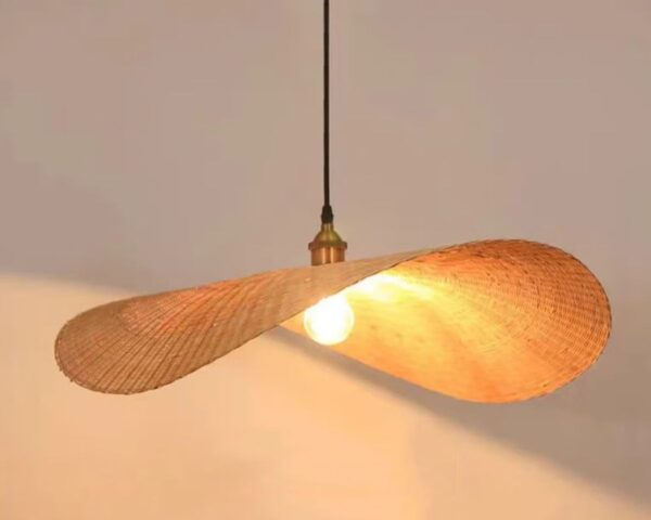 Suspension osier rétro chic base noire allumée sur fond beige.