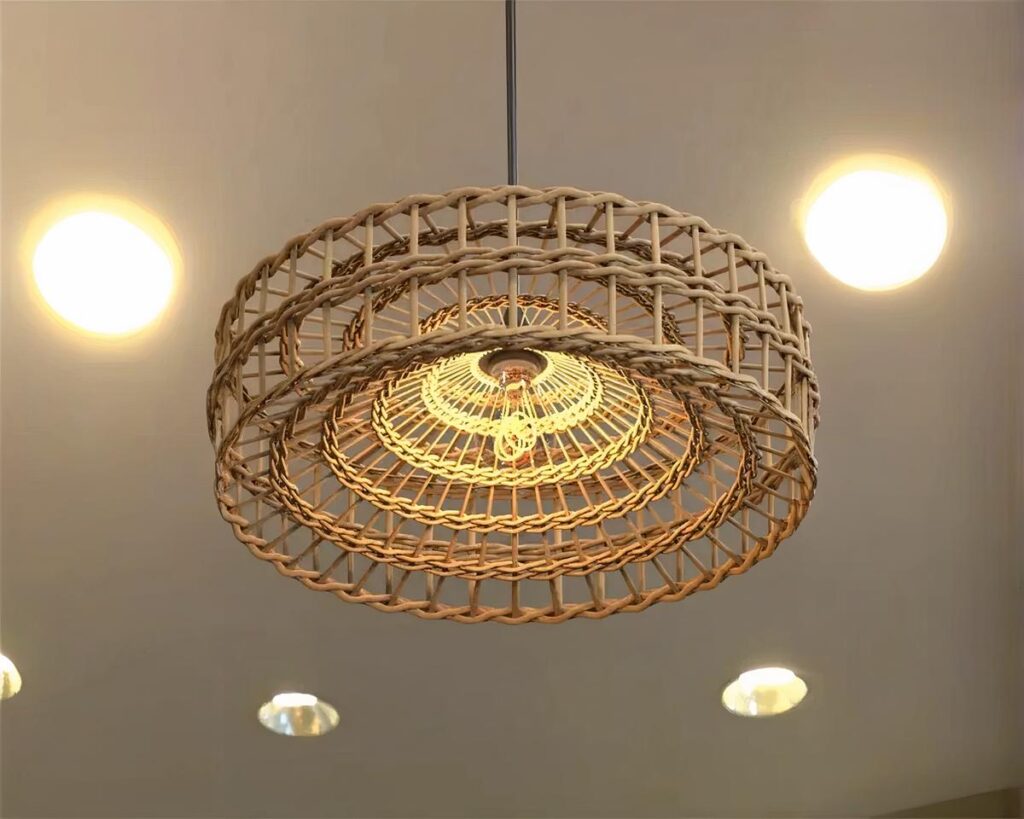 Suspension osier ronde et élégante, de couleur beige, suspendue au plafond.