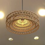 Suspension osier ronde et élégante, de couleur beige, suspendue au plafond.
