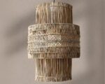 Suspension osier style architectural, de couleur beige et en forme de tube, suspendue . Fond beige clair.