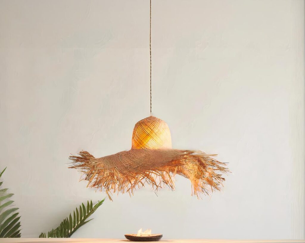 Suspension paille LED intemporelle et raffinée sur fond gris avec une plante verte en bas