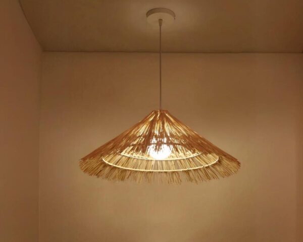 Suspension paille LED tendance faite à la main sur fond marron.