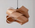 Suspension bois décorative et artistique sur fond gris.