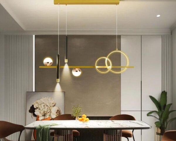 Suspension XXL design géométrique, de couleur dorée et suspendue au dessus d'une table de salle à manger.