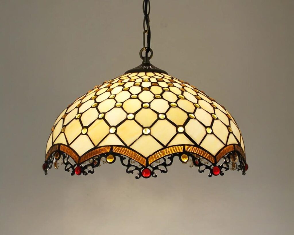 Suspension rétro vitrail baroque, de couleur jaune, allumée et suspendue. Fond beige.