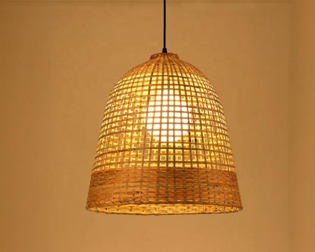 Suspension rotin en forme de cloche sur fond beige.