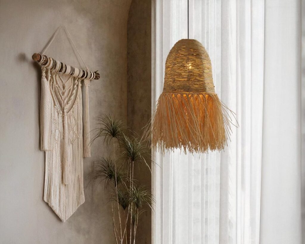 Suspension style raphia en cloche frangée, installé dans une pièce de vie à côté d'une grande fenêtre avec des rideaux blanc.