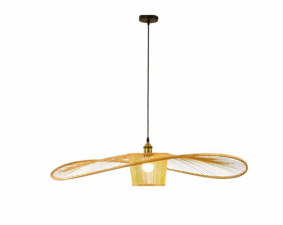 Suspension style vertigo moderne en bambou, installée dans un salon au-dessus d'une table basse en bois avec un canapé gris foncé.
