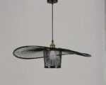Suspension style vertigo moderne en bambou noir sur fond gris.