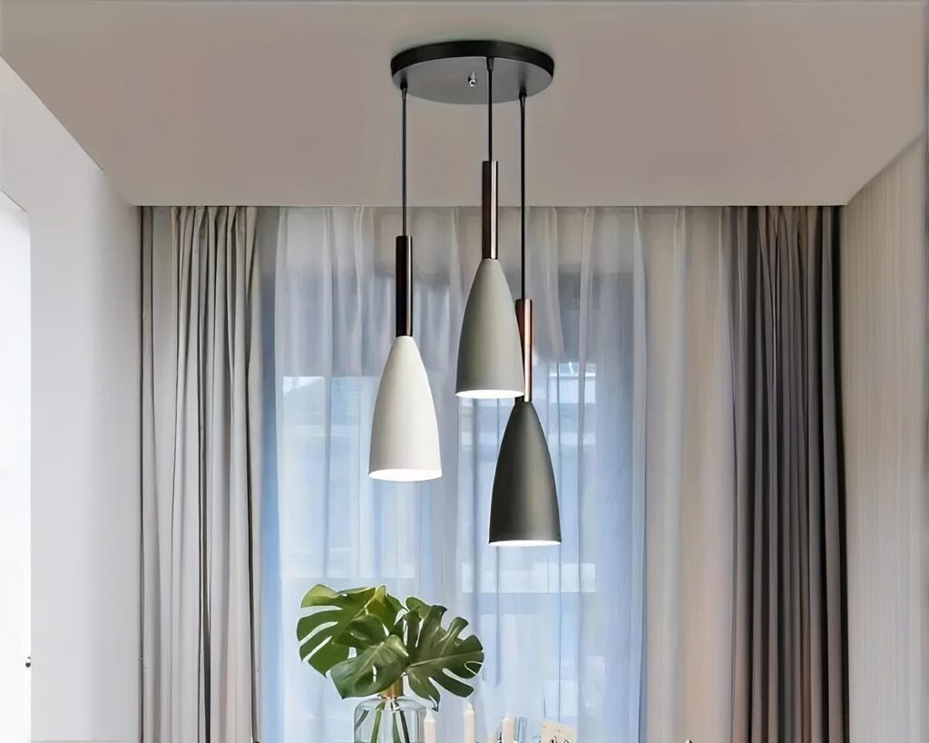 Suspension trois lampes design et moderne allumée dans un salon