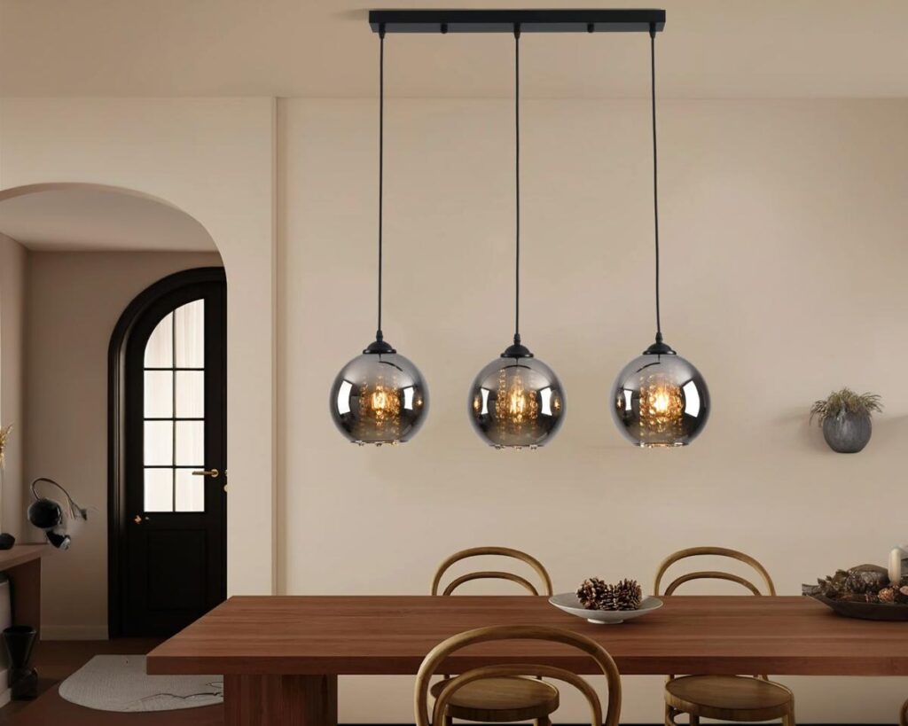 Suspension trois lampes élégante au style luxueux allumée dans une salle à manger