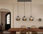 Suspension trois lampes élégante au style luxueux allumée dans une salle à manger