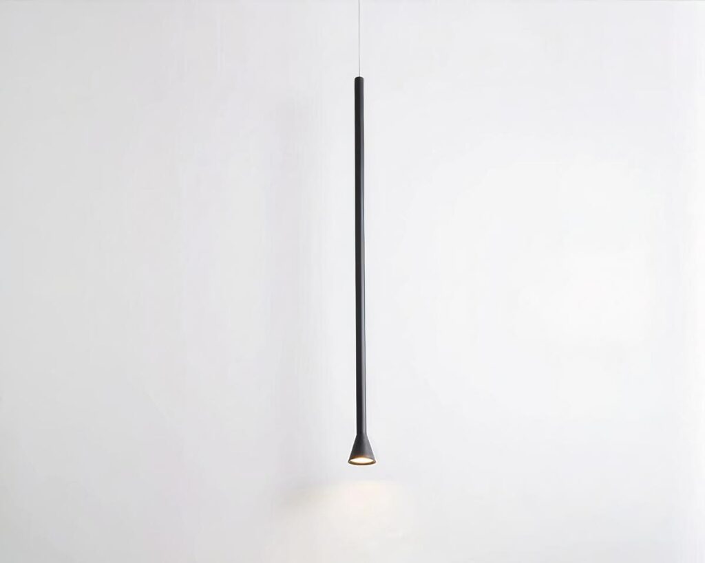 Suspension tube LED fine et élégante en aluminium noire allumée sur fond gris