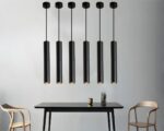 Suspension tube noire design et moderne allumรฉe dans une salle ร manger