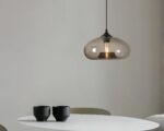 Suspension verre fumé translucide et captivante au-dessus d'une table avec des tasses