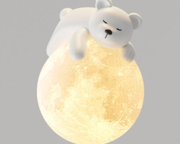 Suspension chambre bébé en forme de globe avec ourson blanc allongé dessus. Le globe est blanc est allumé. Sur fond gris.