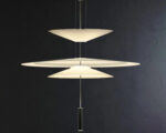 Suspension moderne LED créative et design allumée formée de trois triangles. Sur fond noir.