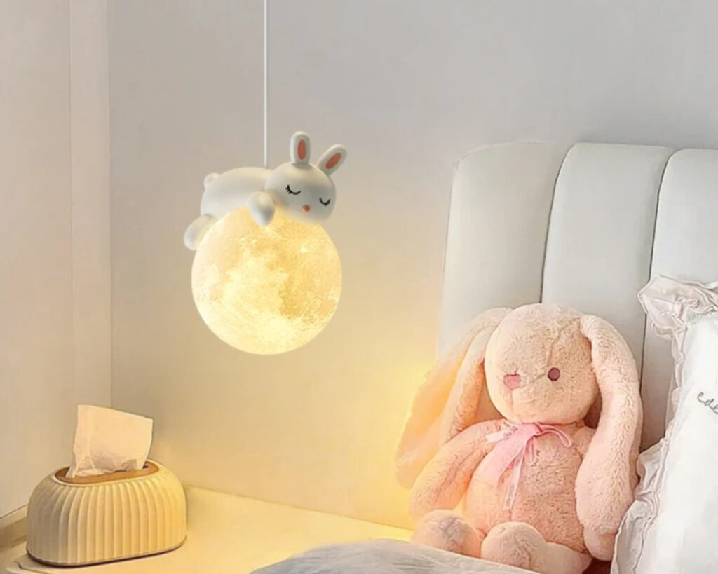 Suspension chambre enfant lune et lapin, suspendue et allumée dans une chambre enfant.