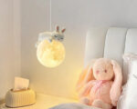 Suspension chambre enfant lune et lapin, suspendue et allumée dans une chambre enfant.